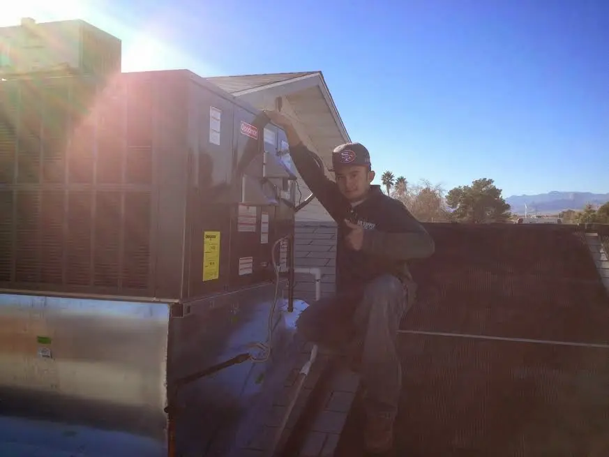HVAC technician performing AC Tune-Up on a rooftop unit in Oxnard